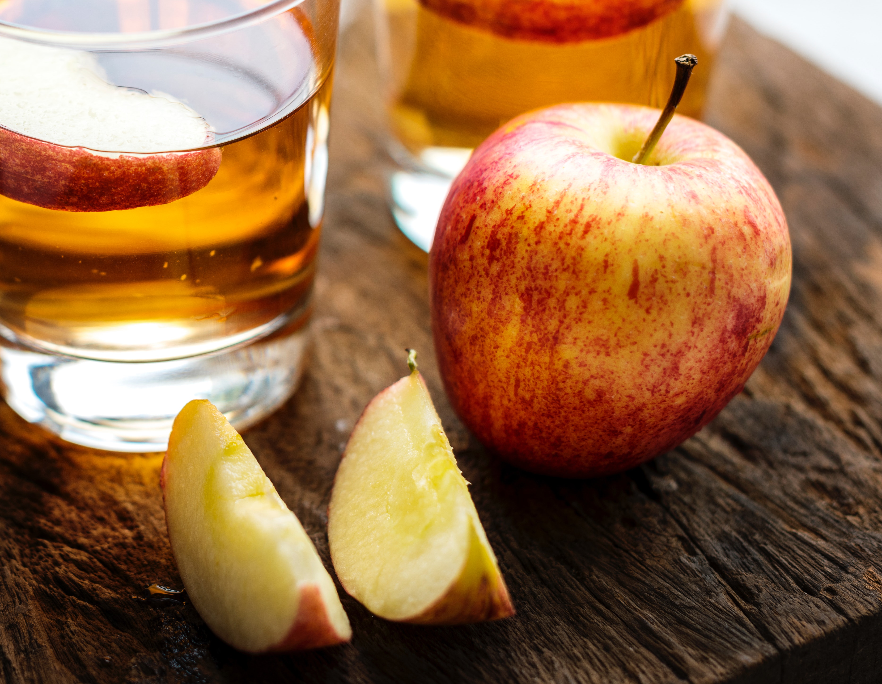 apple juice beverage closeup photo of apples on wooden surface